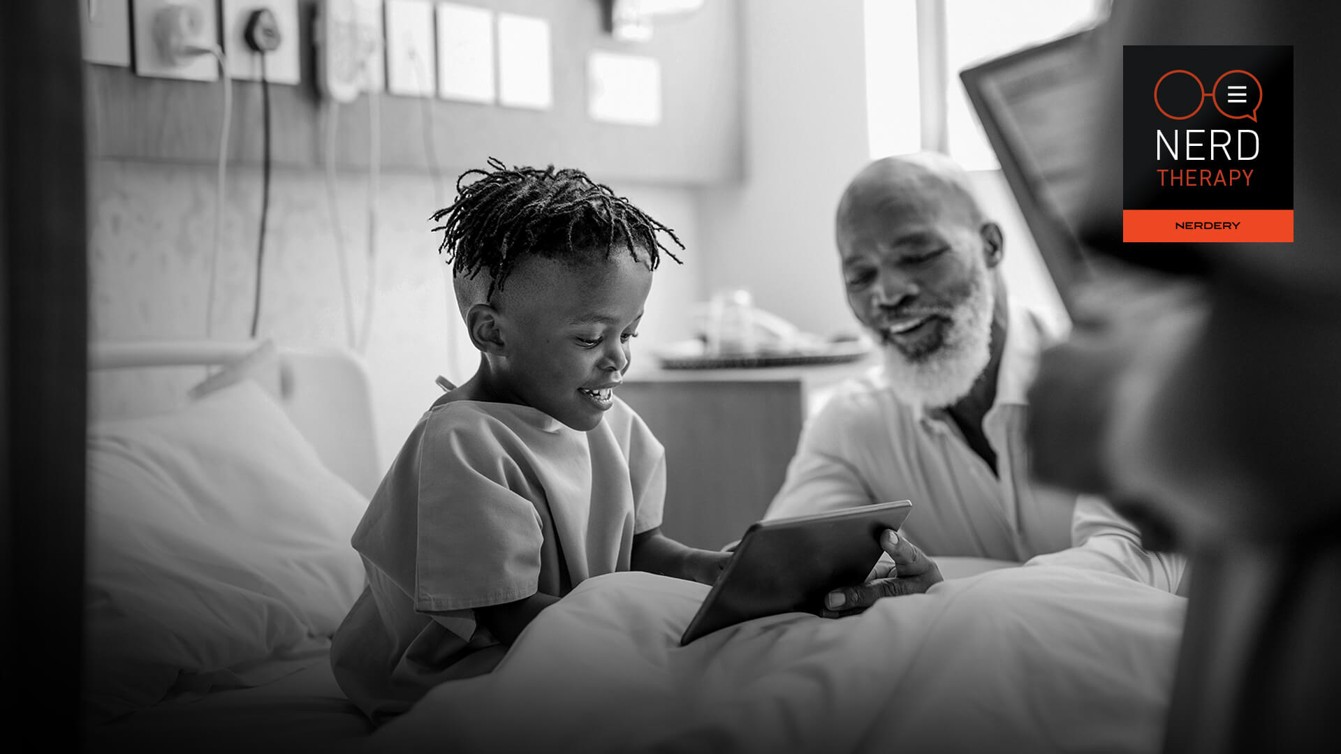 child looks at a tablet device with his doctor