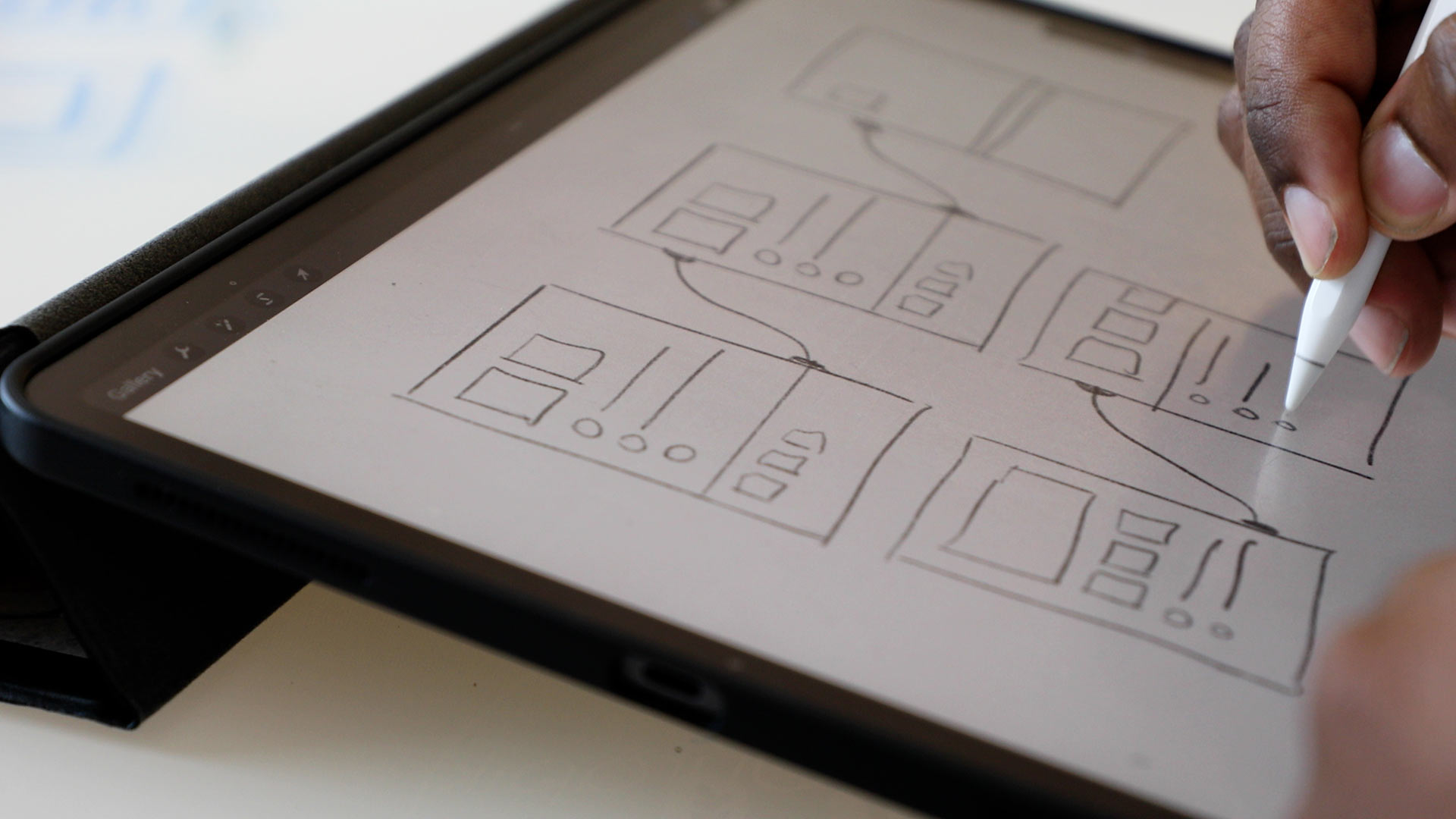 Hand drawing out wireframes on a tablet with a stylus
