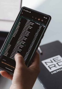 Hand holding up a phone with a spreadsheet on screen
