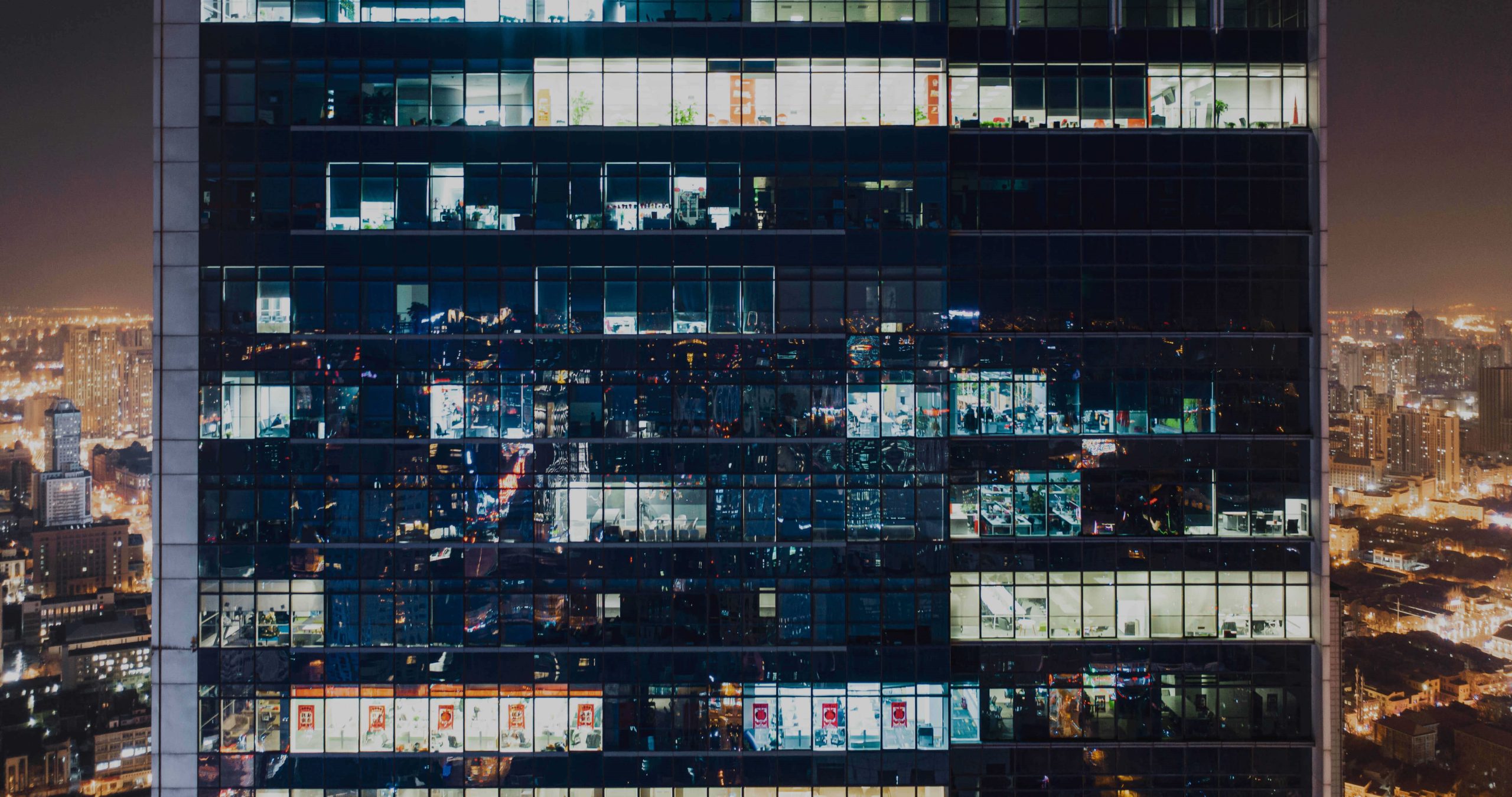 Image of an office building at night with window lit up