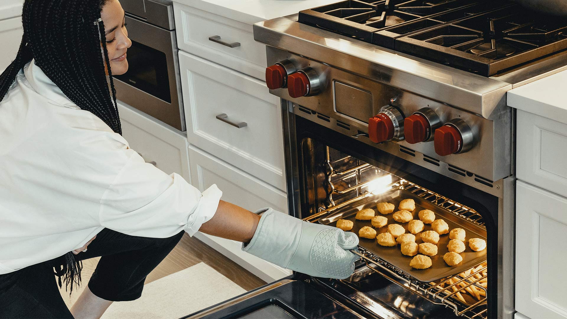 Woman taking food out of the oven